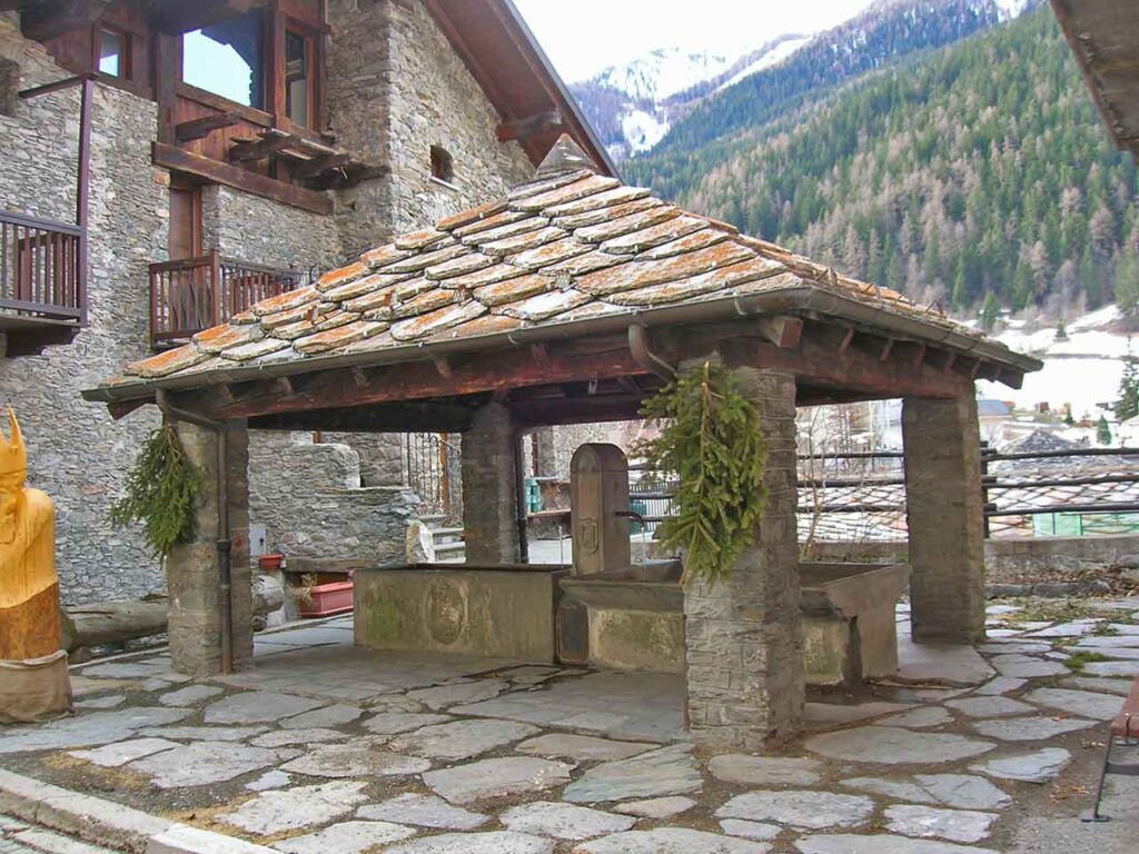 Luoghi da visitare a gennaio in camper: un antico fontanile a Étroubles (AO).