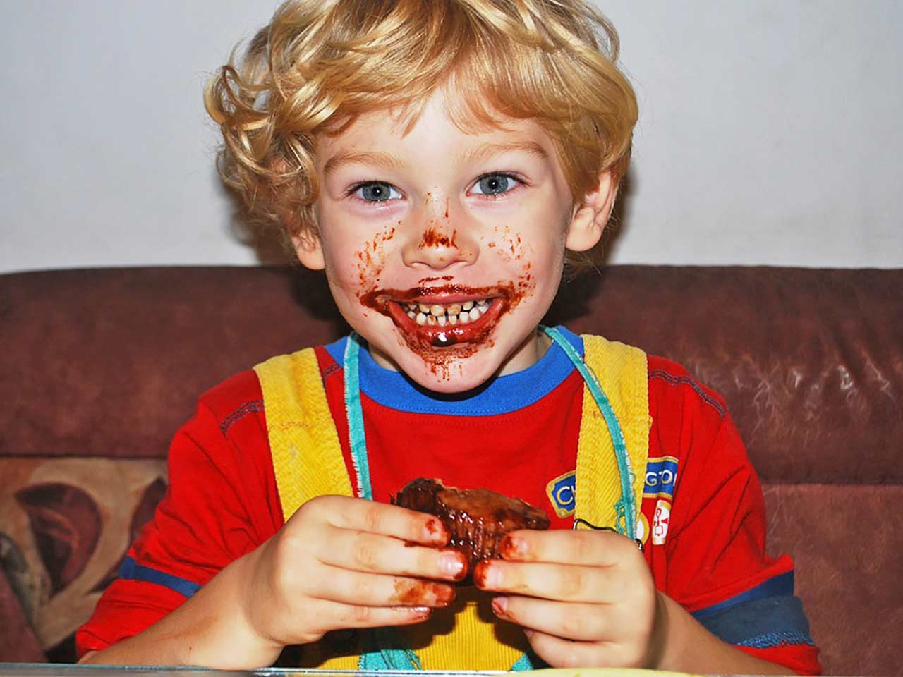 Lallegria di un bambino mentre mangia un dolce - Gusto, un semaforo in bocca.