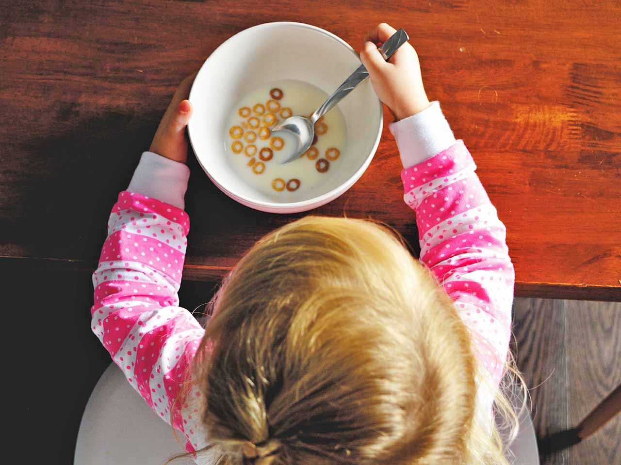 Il fruttosio, lo zucchero più nocivo: un bambino che mangia cereali in scatola industriali
